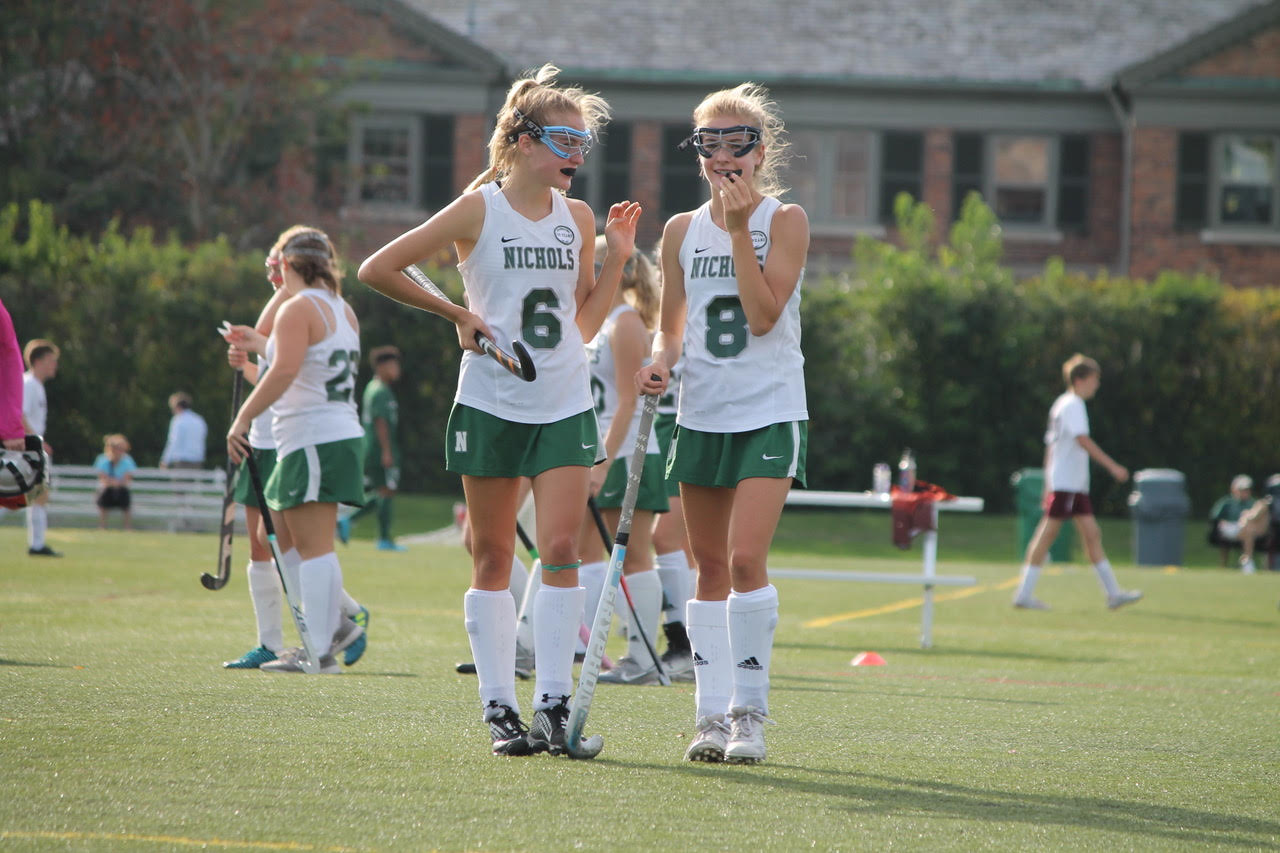 Emily and Lyla playing field hockey